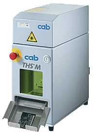Laserový značkovač pro výrobu typových štítků THS+M s namontovanou laserovou hlavou laseru FL+ viditelnou v horní části obrázku.